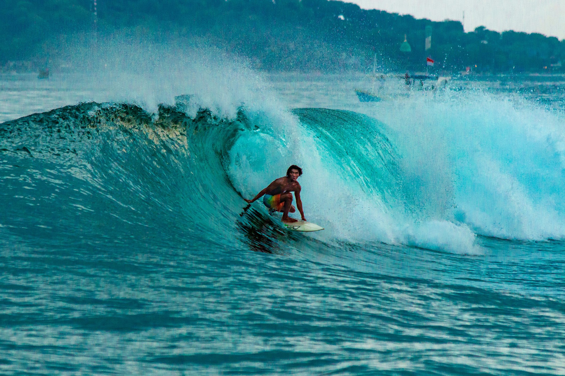 Bali surfer riding a wave along the coast
